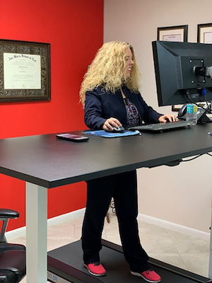Dawn Maselli on a treadmill desk at the offices of Associates and Bruce L. Scheiner, Attorneys for the Injured